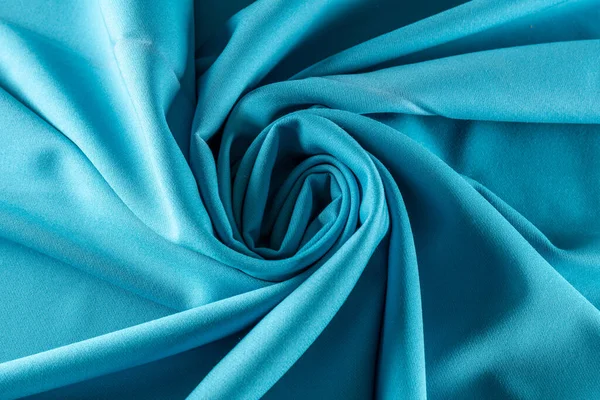 sky blue fabric for tailoring rolled into a spiral, background