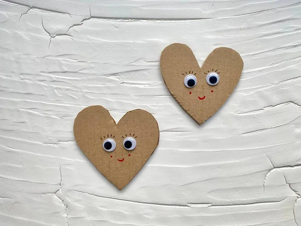 Dos corazones de cartón con ojos y una sonrisa. — Foto de Stock