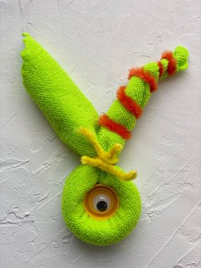 Tek gözü mikrofiber kumaş ve lastik bantlardan yapılmış şirin yeşil bir canavar.