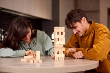 Oturma odasında Jenga oynayan çift. Aileniz evde iyi eğlenceler.