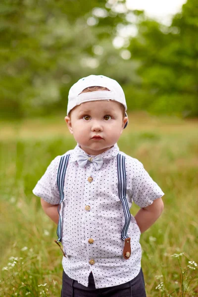 Liten Seriös Pojke Hängslen Och Mössa Gömmer Händerna Bakom Ryggen — Stockfoto