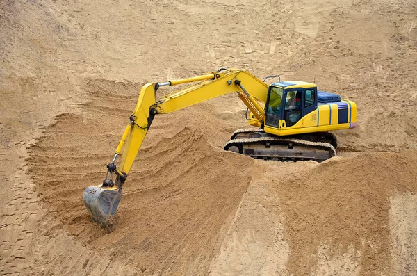 Escavadora amarela nivela seu balde de areia, terra, argila. Construção de um aterro de areia — Fotografia de Stock