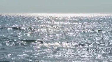 Suyun bulanık güneş yansımaları, bulanık güneş lekeleri denizin, okyanusun, nehrin yüzeyinde.