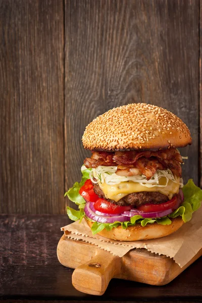 Hamburgare på skärbräda. Stockbild