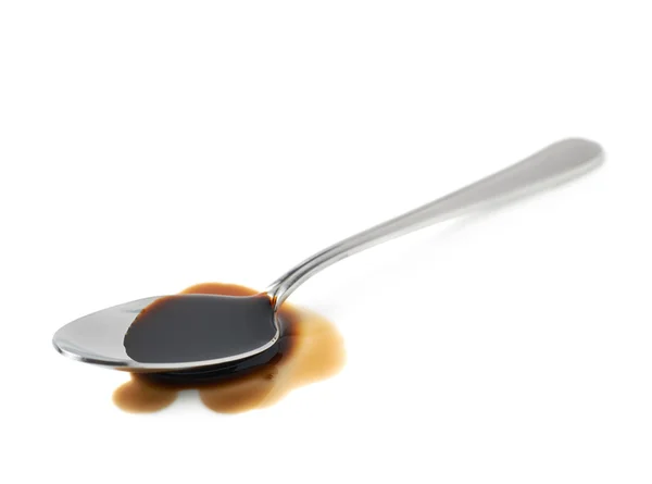 Łyżka ze stali w kałuży sosu sojowego — Zdjęcie stockowe