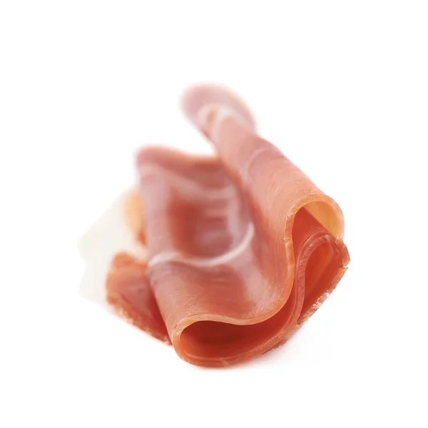 Gevouwen prosciutto-ham segment geïsoleerd — Stockfoto