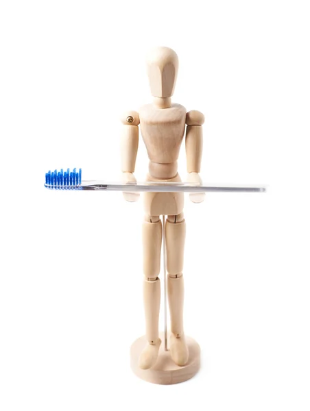 Human wooden doll holding toothbrush — Stock Photo, Image