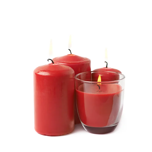 Quatro velas vermelhas acesas isoladas — Fotografia de Stock