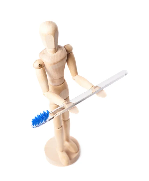 Human wooden doll holding toothbrush — Stock Photo, Image