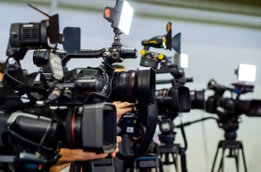 Basın toplantısı. Muhabirler TV kameralarında film çekiyor..