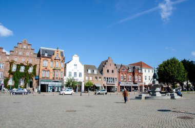 Husum, Almanya - 30 Ağustos 2021: Asmussen-Woldsen-Denkmal (anıt), 'Tine-Brunnen' (çeşme) pazar yerinde.