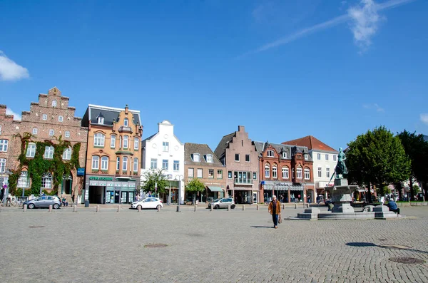 Husum, Almanya - 30 Ağustos 2021: Asmussen-Woldsen-Denkmal (anıt), 'Tine-Brunnen' (çeşme) pazar yerinde.