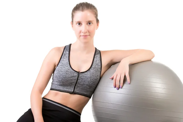 Donna in piedi in piedi tenendo una palla di pilates — Foto Stock