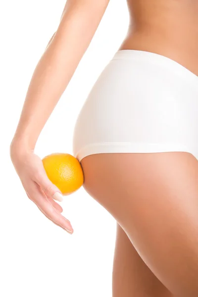 Kvinna med en Orange mot hennes lår — Stockfoto