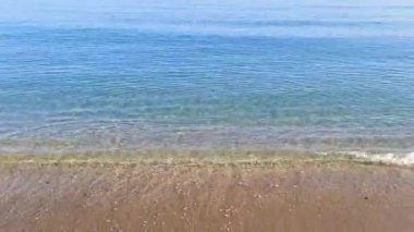 Akdeniz kıyılarındaki güzel deniz dalgaları. Temiz mavi su, kum. Yüksek kalite 4k görüntü