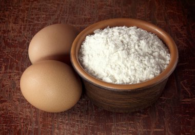 Kırsal ahşap masa üzerinde beyaz un ile pişirme arka planı. Unlu fırıncı işyeri