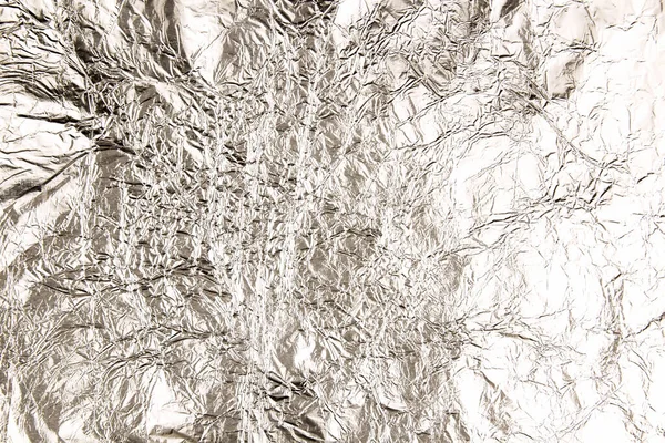 sheet of silver leaf aluminum foil background with shiny crumpled uneven surface