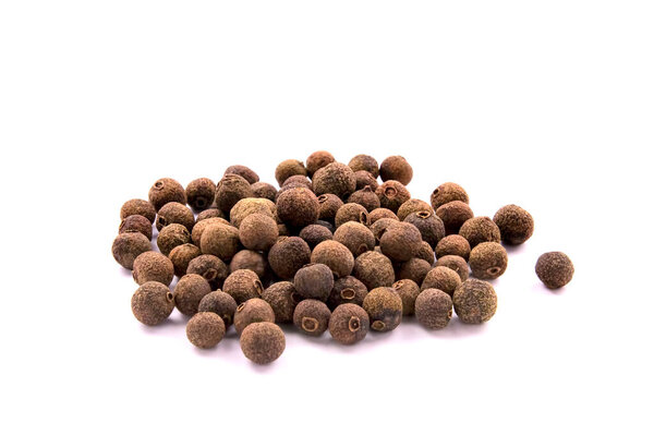 Куча специй выделена на белом фоне. Ямайский перец, перец со специями или миртовый перец