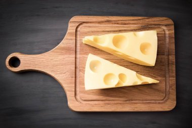 Tahtadaki taze peynir. Siyah arka planda, lezzetli, doğal.