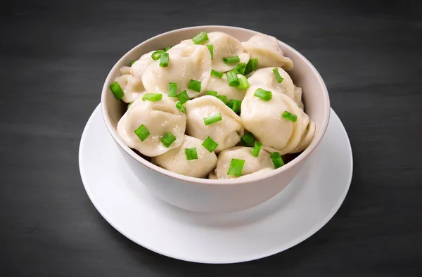Meat dumplings - Russian dumplings, dumplings with meat on a plate on a black background