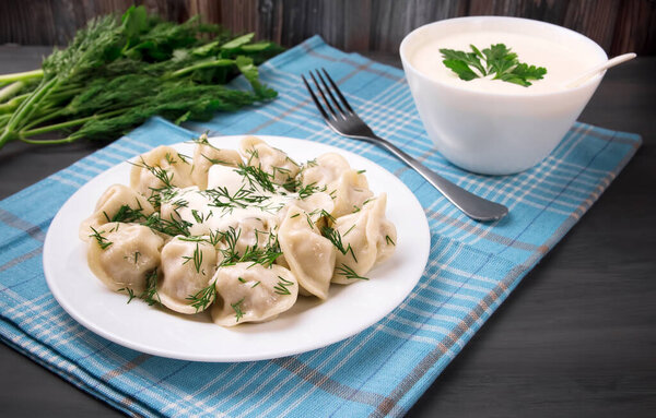 Мясные пельмени - российские пельмени, пельмени с мясом на тарелке на черном фоне