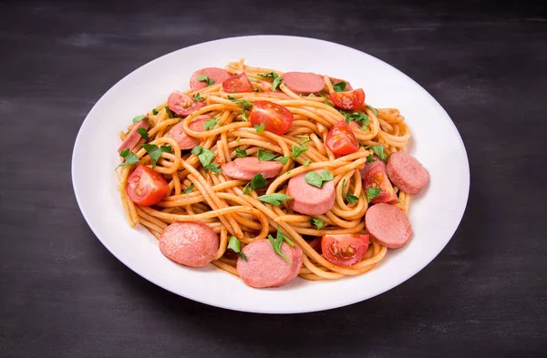 Makaron Spaghetti Pomidorami Wiśniowymi Smażoną Kiełbasą Pietruszką Białym Talerzu Czarnym Zdjęcie Stockowe