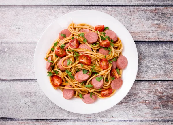 Nudelspaghetti Mit Kirschtomaten Bratwurst Und Petersilie Auf Weißem Teller Auf lizenzfreie Stockbilder