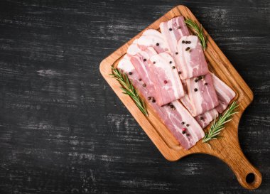 Baharatlı çiğ domuz pastırması ve siyah arka planda biberiye, çok lezzetli.