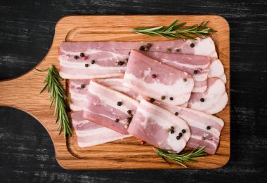 Baharatlı çiğ domuz pastırması ve siyah arka planda biberiye, çok lezzetli.