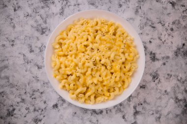 Beyaz tabakta gri arka planda peynirli makarna. Amerikan peynirli makarna