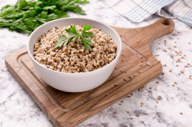 Gri arka planda bir tabakta taze pişmiş karabuğday lapası. Sağlıklı yiyecekler. Vejetaryen yemeği..