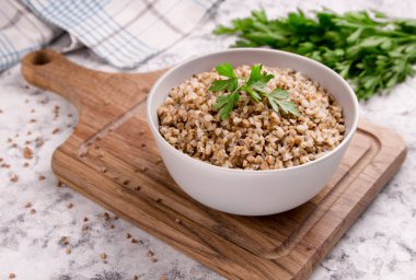 Gri arka planda bir tabakta taze pişmiş karabuğday lapası. Sağlıklı yiyecekler. Vejetaryen yemeği..