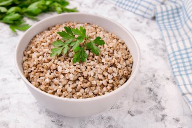 Gri arka planda bir tabakta taze pişmiş karabuğday lapası. Sağlıklı yiyecekler. Vejetaryen yemeği..