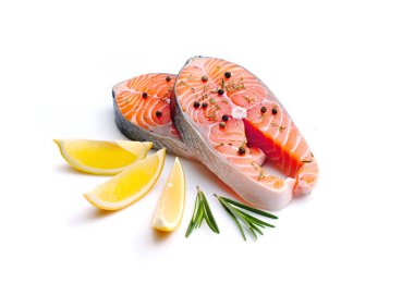 Beyaz arka planda biberiyeli, limonlu ve biberli taze somon bifteği.