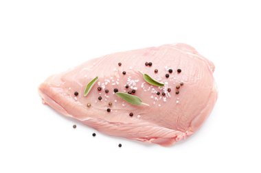 Beyaz arka planda baharatlı çiğ hindi filetosu. Pişmemiş hindi eti nugget ya da escalope için..