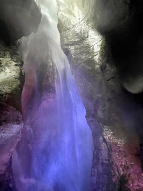 Mağarada renkli ışıklarla çağlayan del Varone Riva del Garda