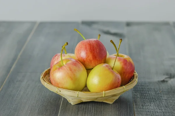 แอปเปิ้ลสีแดงและสีเหลืองบนพื้นหลังไม้ — ภาพถ่ายสต็อก