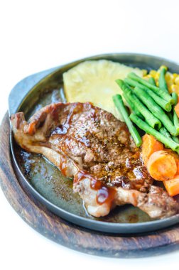 Dökme demir tava yanında sebzeli ızgara biftek