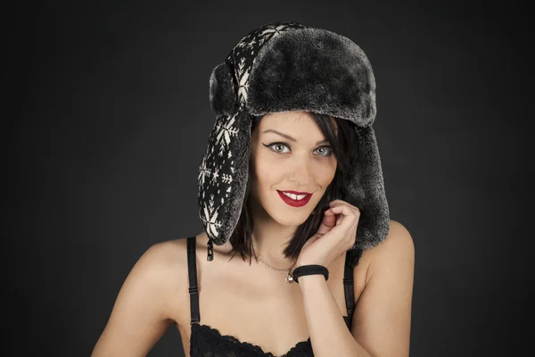 Ragazza con un cappello su uno sfondo nero — Foto Stock