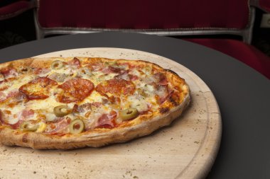 ahşap plaka üzerinde bükülmüş pizza