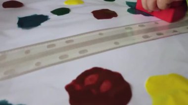 Yeni yürümeye başlayanlar için el işleri. Jelibon bloklarıyla boyama Plastik klasörle kapatılmış boyayı indirir