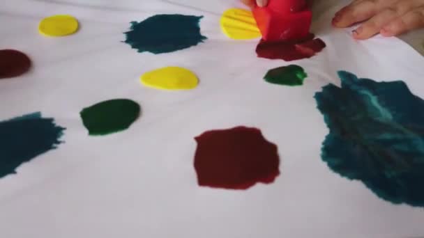 Crafts for toddlers. Painting with gummy blocks ower the paint closed in plastic folder — Stock Video