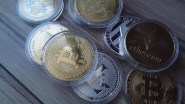 Ahşap yüzeye saçılmış kripto paralar. Bitcoin, Litecoin, Ethereum ve Dalgalanma