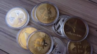 Ahşap yüzeye saçılmış kripto paralar. Bitcoin, Litecoin, Ethereum ve Dalgalanma