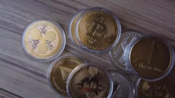 Крипто-монети розкидані по дерев'яній поверхні. Bitcoin, Litecoin, Ethereum and ripple — стокове відео