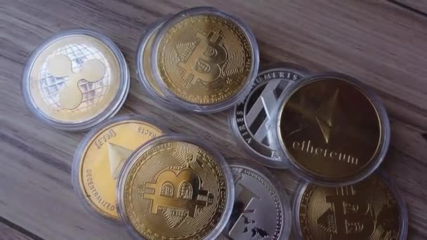 Koin Crypto terserak di atas permukaan kayu. Bitcoin, Litecoin, Ethereum dan riak — Stok Video