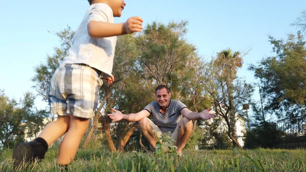 Un bambino che corre da suo padre nel parco. Angolo basso — Foto Stock