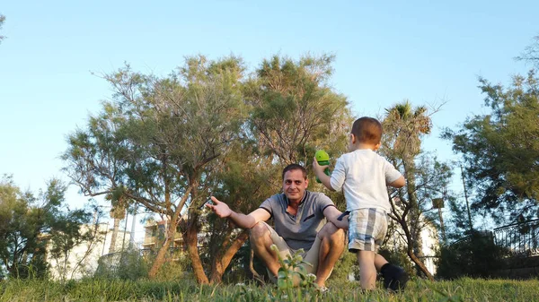 Un niño corriendo hacia su padre en el parque. Ángulo bajo — Foto de Stock