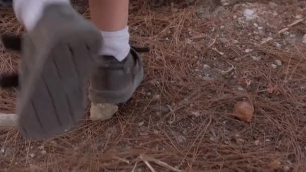 Child running in the park on dry dusty terrain . Low angle tilting shot — Αρχείο Βίντεο