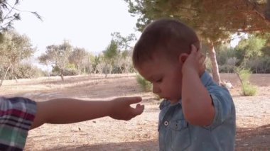Sevimli çocuklar, 4-3 yaşlarındaki kardeşler el ele tutuşup parkta yürüyorlar. Zorunlu yüz maskesi takan anaokulu çocuğu.